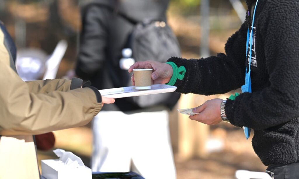 ONSEN・ガストロノミーウォーキング in 那須塩原2025で、飲み物を参加うけとる様子