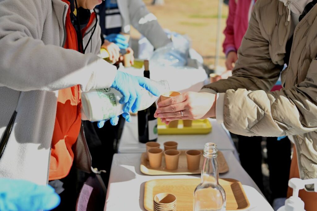 ONSEN・ガストロノミーウォーキング in 那須塩原2025で、参加者が牛乳を受け取る様子