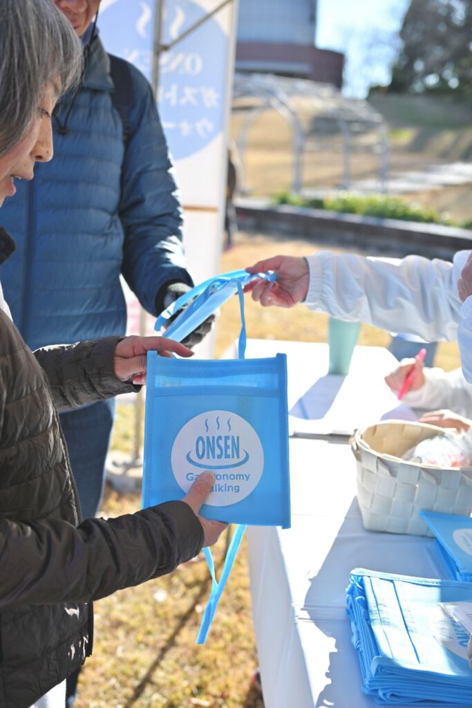 ONSEN・ガストロノミーウォーキング in 那須塩原2025で、サコッシュを配る様子