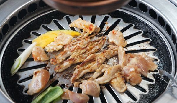 円形の鉄板の上でチキンが焼かれているチキンハウスの様子