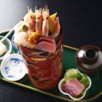 桶に盛られた海老や刺身の海鮮と、小鉢・お吸い物が付いた錦鮨の料理
